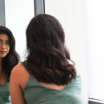 Carol: CEFALY me devolvió la vida a woman looks at her reflection in a bathroom mirror