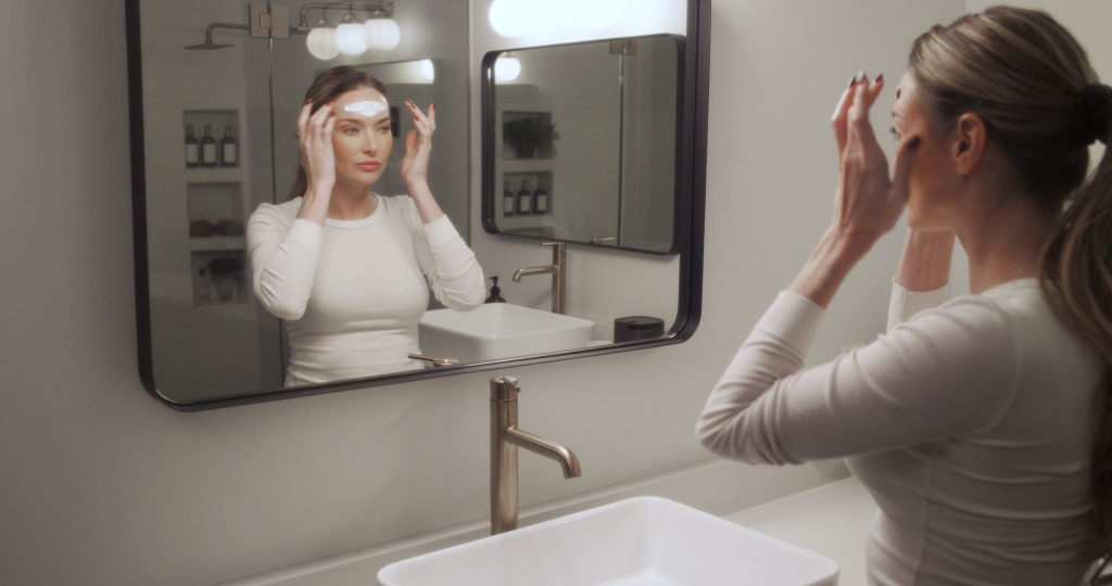 Person using the Cefaly device on their forehead for migraine relief at home.